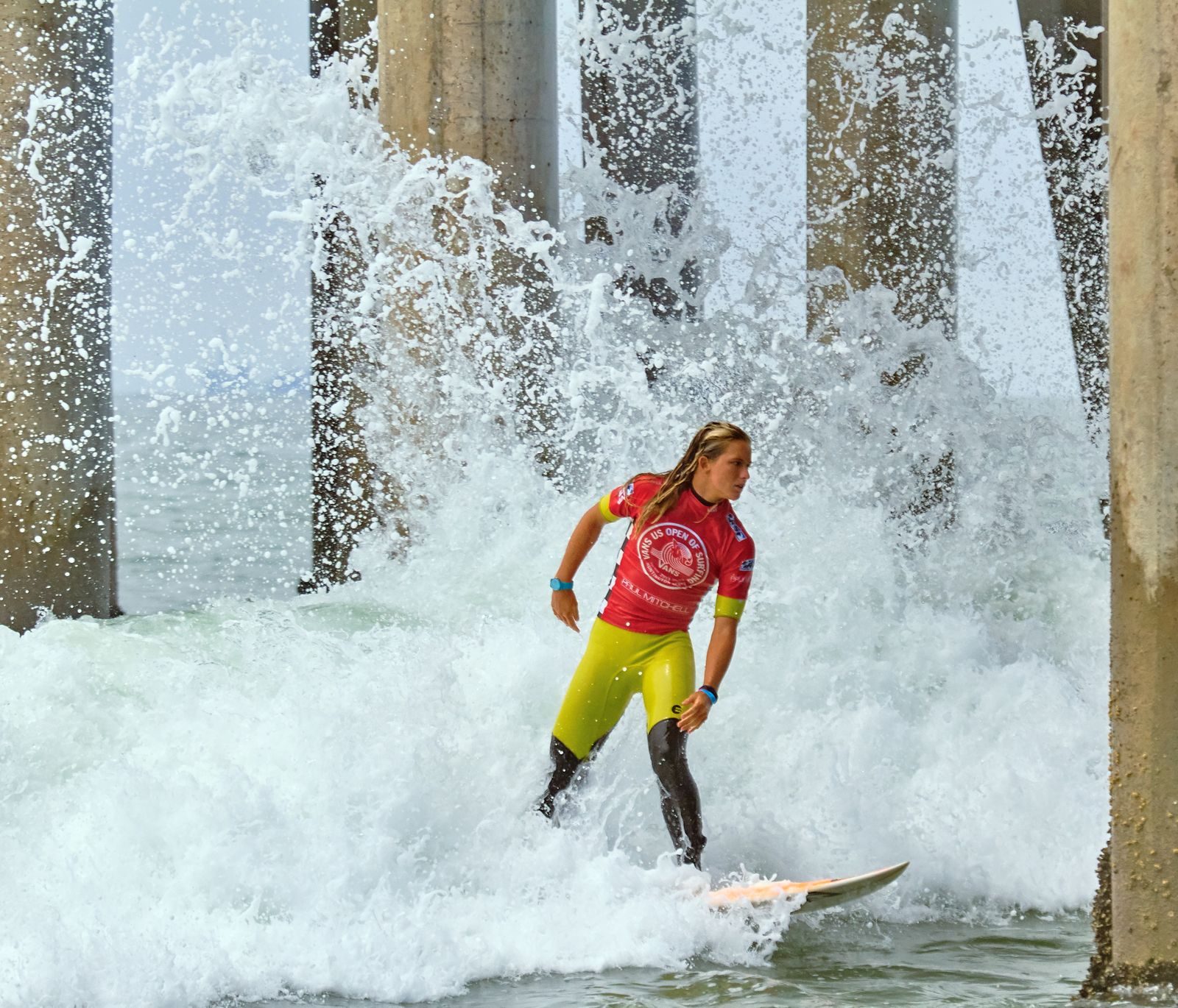 A surfer rides through the Huntington Beach Pier. A Great Day in the Stoke returns Oct. 10 for its fifth annual gathering.
