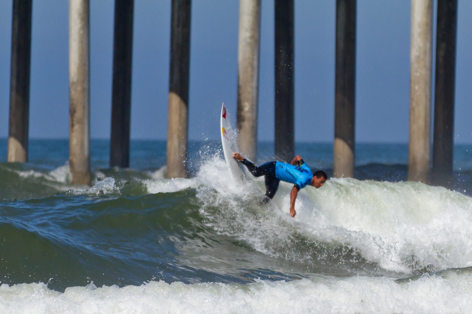 File photo: a competitor turns on a wave in front of the Huntington Beach Pier pilings during the U.S. Open of Surfing. Julian Williams won his fifth straight Stoke men's longboard title on Saturday.