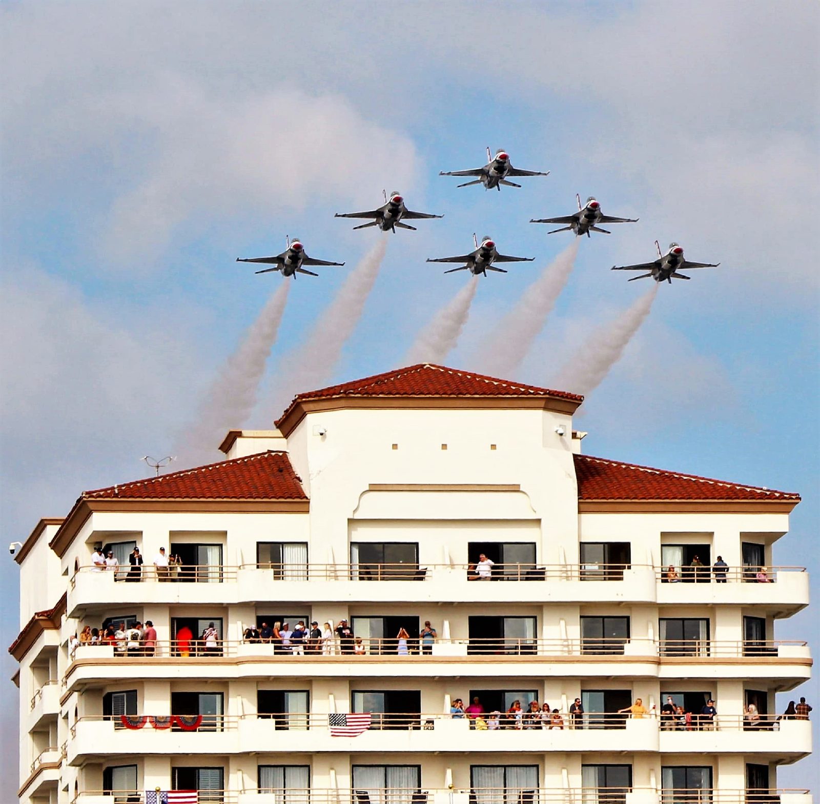 The U.S. Air Force Thunderbirds fly in formation over a beachfront building during the Pacific Airshow at Huntington Beach.