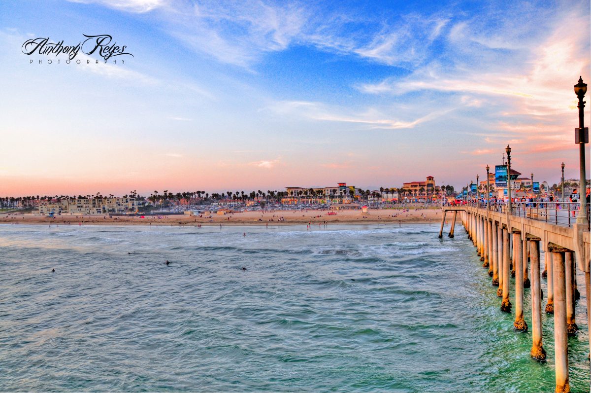 Surfers line the water off the Huntington Beach Pier at sunset. Forecasters expect surf of 6 to 9 feet at south-facing beaches in Orange County on Sunday.