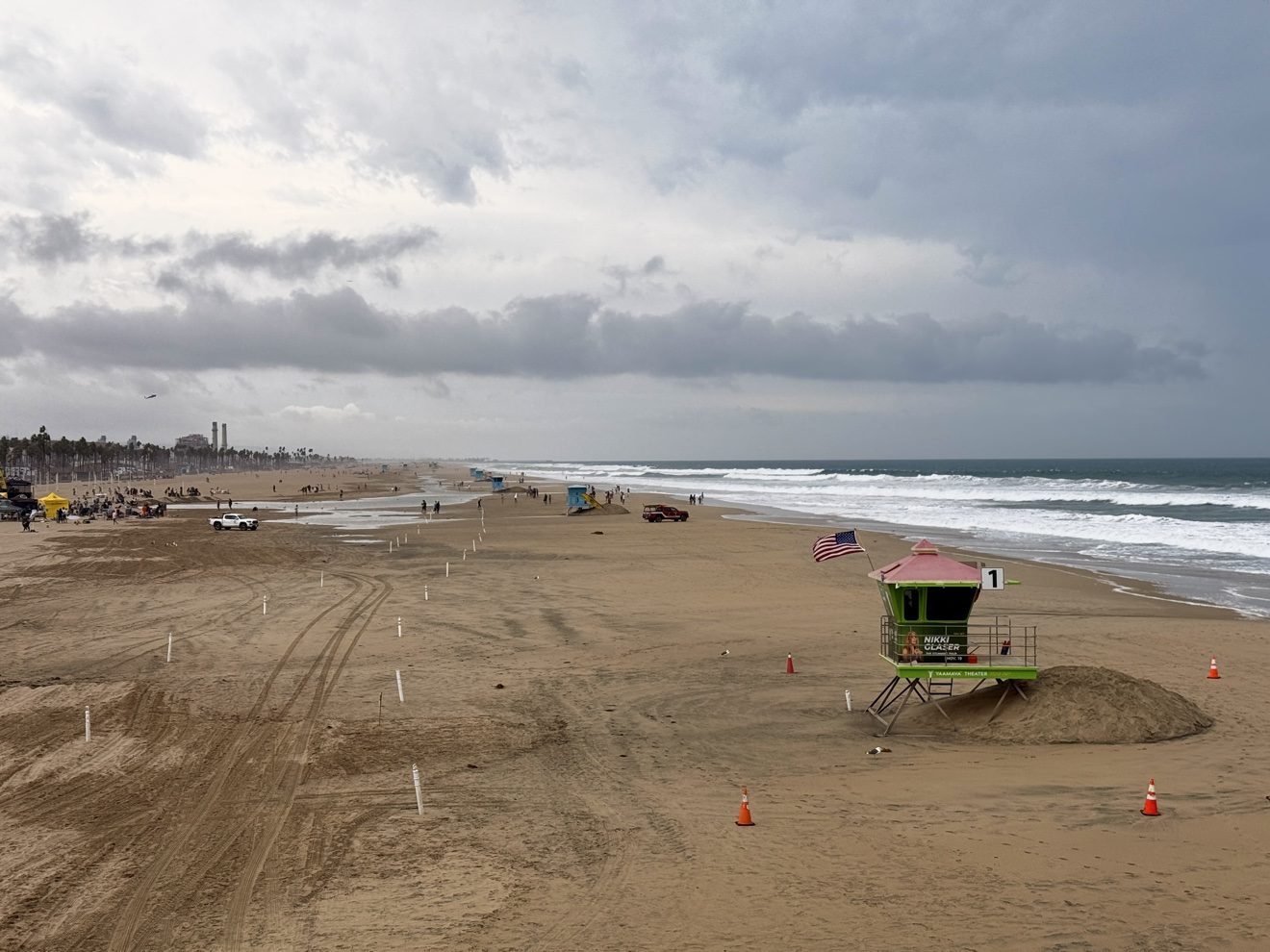 Dark storm clouds offshore beyond lifeguard tower 1 on Saturday, Oct. 10, 2026. A beach hazards statement takes effect Sunday morning, with surf of 5 to 7 feet and local sets up to 9 feet.
